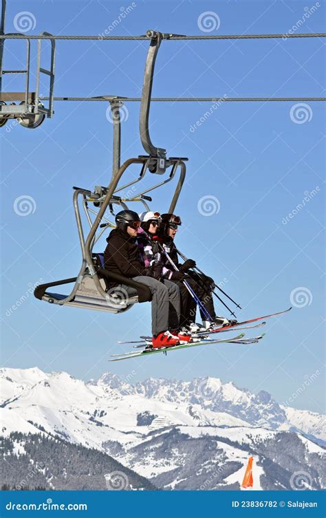 Immagine di sciatori che godono del panorama innevato, con gli impianti di risalita sullo sfondo.