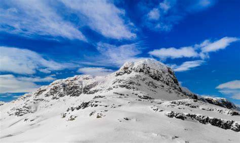 Sciatore in cima a una vetta innevata con vista panoramica