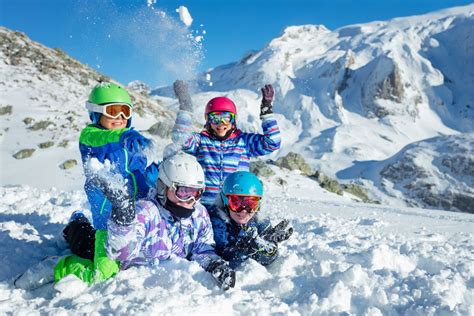 Bambini che giocano in un asilo sulla neve con gonfiabili e giochi