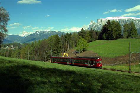 Vista del trenino del Renon che attraversa un paesaggio alpino