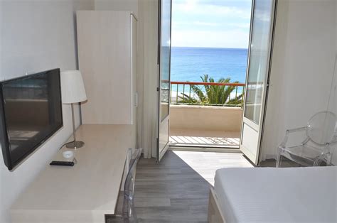 Camera d'albergo con balcone arredato e vista panoramica sul lago