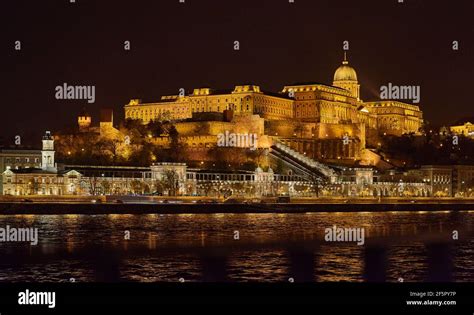Vista notturna del Castello di Buda illuminato, con il Ponte delle Catene in primo piano