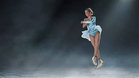 Una pattinatrice artistica esegue un triplo axel in aria.