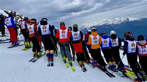 Maestri di sci sorridenti che insegnano a bambini su una pista innevata a Civetta
