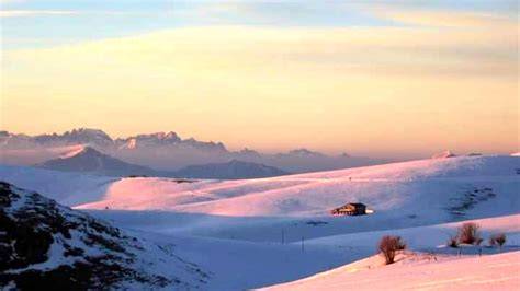 Panorama notturno innevato della Lessinia con la luna piena