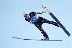 Atleta di combinata nordica in azione durante un salto con gli sci