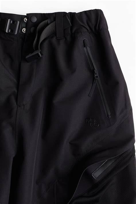 Immagine che mostra in dettaglio le caratteristiche pratiche dei pantaloni da snowboard: prese d'aria, orli rinforzati, tasche con zip.