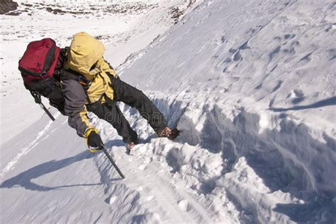 alpinista che utilizza la piccozza per l'auto-arresto su pendio nevoso