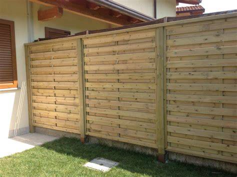 Esempio di barriera frangivento in legno installata lungo una pista da sci con segnaletica fluorescente