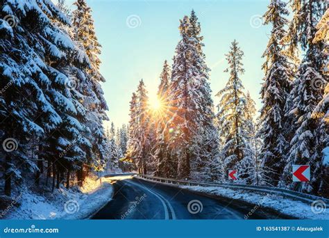 Immagine di una strada innevata che porta a un impianto sciistico chiuso, con un cartello di divieto.