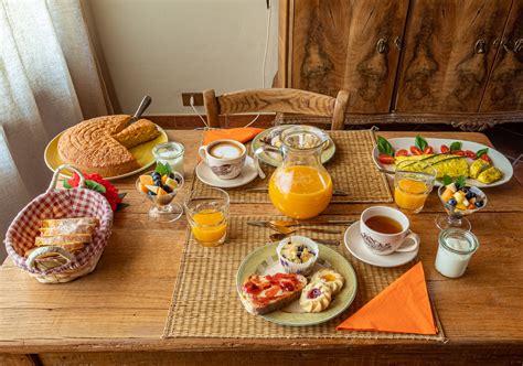Tavola della colazione con assortimento di prodotti locali, marmellate e pane fresco