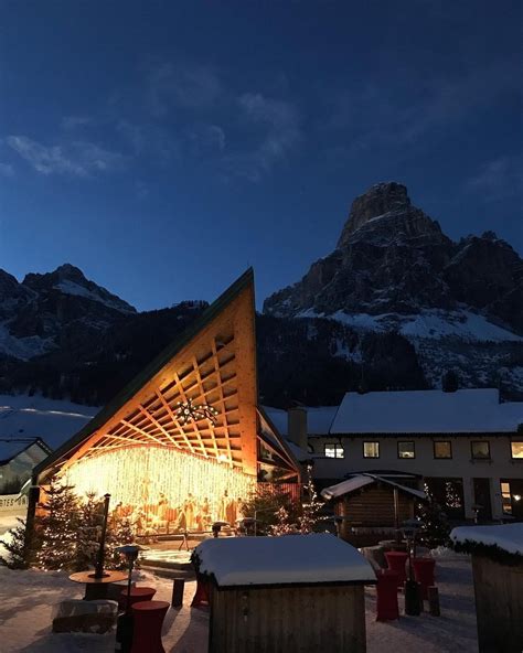 Vista esterna dell'Hotel Sassongher con le Dolomiti innevate sullo sfondo