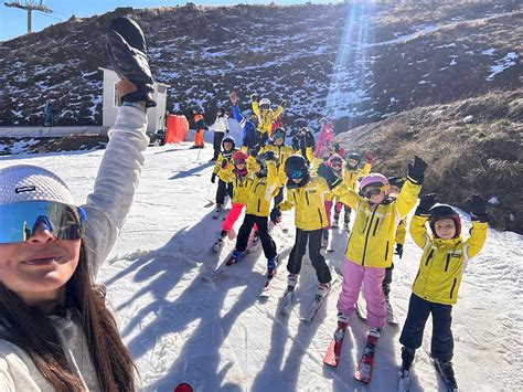 Gruppo di snowboarder che partecipano a una lezione collettiva con un maestro