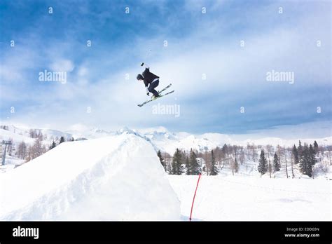 Sciatore che esegue un salto in uno snowpark