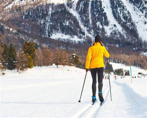 Sciatore che utilizza sci con sciolina gialla su pista innevata
