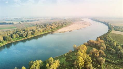 vista di un piccolo imbarcadero sul fiume Po con capanni di pescatori e vegetazione rigogliosa