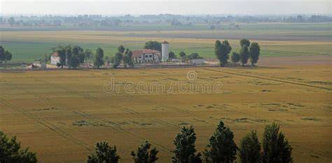 panorama del fiume Po con campi coltivati e campanili di un borgo in lontananza