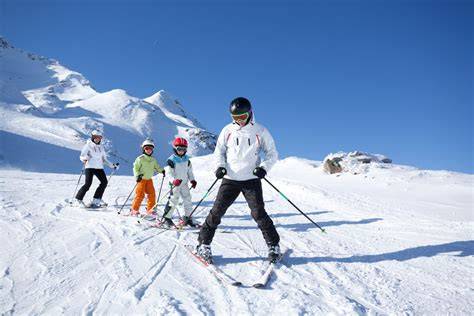 Famiglia che scia sorridendo sulle piste innevate del Trentino