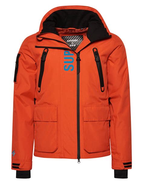 Schema tecnico che evidenzia le caratteristiche della giacca da sci Superdry Ultimate Rescue, come impermeabilità, traspirabilità e dettagli funzionali.
