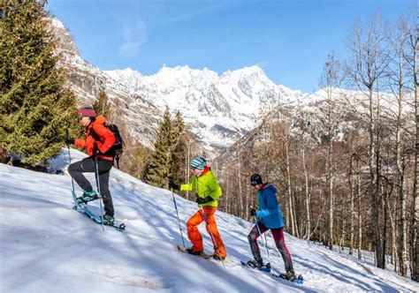bambini che camminano con le ciaspole in un bosco innevato