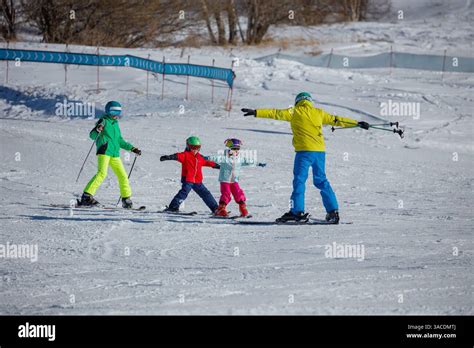 Bambini che imparano a sciare su una pista azzurra con istruttori