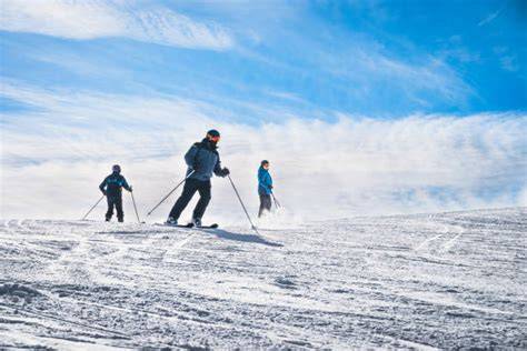 Immagine di persone che sciano in montagna con abbigliamento tecnico colorato.
