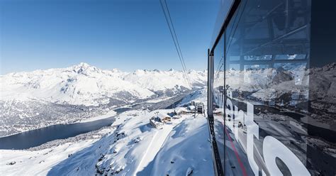 Vista panoramica dalla cima del Corvatsch con sciatori che scendono su piste innevate