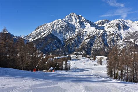 Panorama innevato di Sansicario con le piste da sci e le tradizionali baite di montagna.
