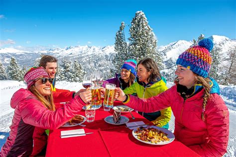 Un gruppo di amici che brinda in un rifugio di montagna con vista sulle Alpi