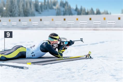 Atleta di biathlon in posizione di tiro a terra.