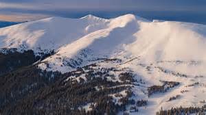 Panorama alpino con vette innevate e un gruppo di sci alpinisti in lontananza