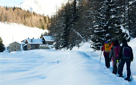 coppia che passeggia sulla neve sull'altopiano del Monte Pana con montagne sullo sfondo