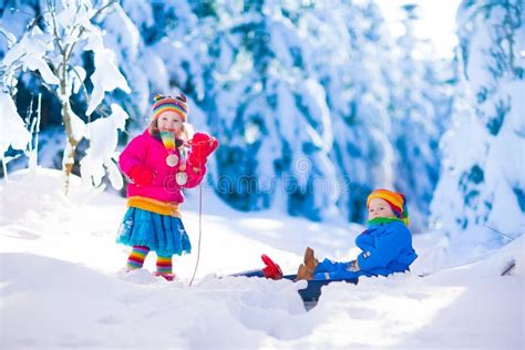 Bambini che si divertono su un tapis roulant magico in una zona sciistica per famiglie