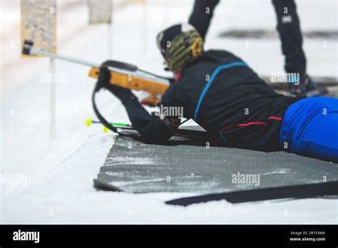 Un biatleta equipaggiato con fucile, sci e abbigliamento tecnico.