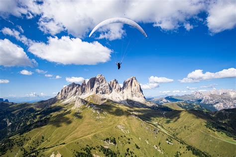 Parapendio in volo sopra il Col Rodella con le Dolomiti sullo sfondo