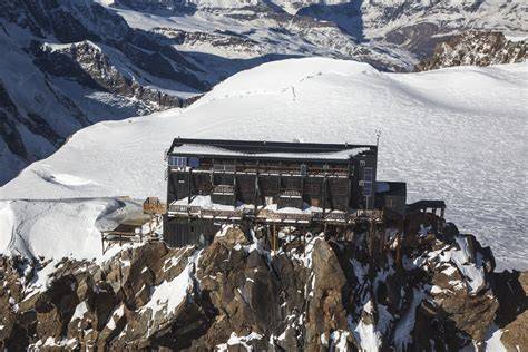 Rifugio Margherita sulla Punta Gnifetti, con un campo innevato e montagne sullo sfondo