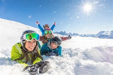 Famiglia che scia felicemente su una pista soleggiata dell'Alpe Cimbra.