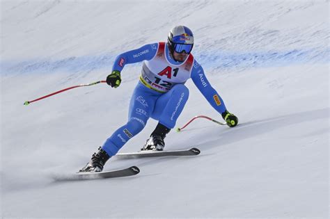Un atleta di sci alpino in azione durante una discesa su una pista innevata.