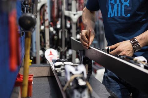 tecnico al lavoro nel laboratorio ski-service con macchinari professionali