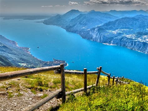 Vista panoramica sul Lago di Garda dal Monte Baldo, con scorci di Malcesine e delle montagne circostanti.
