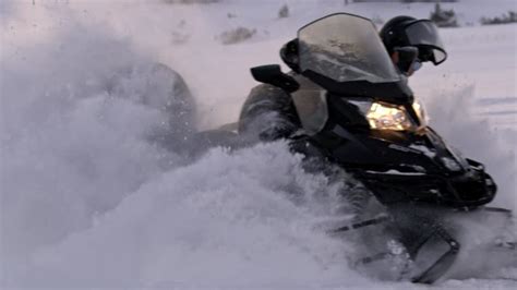 Guida che mostra come guidare una motoslitta in un ambiente innevato
