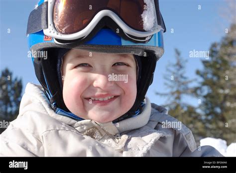 Bambino che prova un casco da sci con occhiali da sci per verificarne la compatibilità