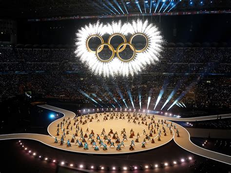 Immagine della cerimonia di apertura delle Olimpiadi Invernali di Torino 2006, con la fiaccola olimpica portata da atleti.