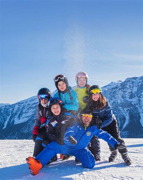 Bambini che indossano abbigliamento da sci colorato, sorridenti su una pista innevata