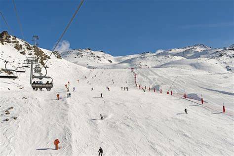 Una panoramica di una vasta area sciistica alpina con piste ben preparate