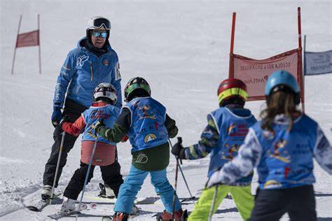 Un istruttore di sci che insegna a un gruppo di bambini su una pista morbida