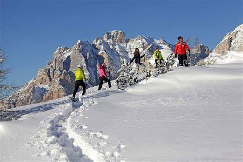 Persone che fanno escursioni con le ciaspole in un paesaggio montano innevato