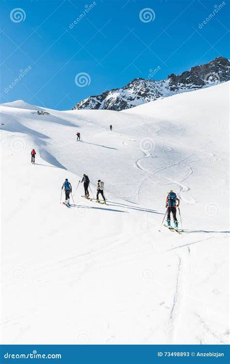 Sci alpinisti che salgono su un pendio innevato con vista sulle montagne