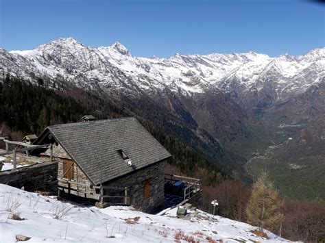 Sentiero invernale con neve e indicazioni per il Rifugio Alpe Corte