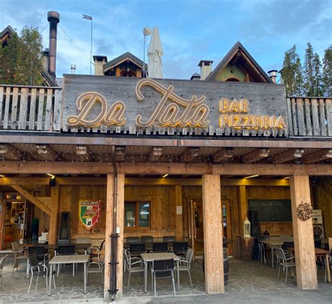 vista esterna della pizzeria Da Tata con insegna e tavoli all'aperto